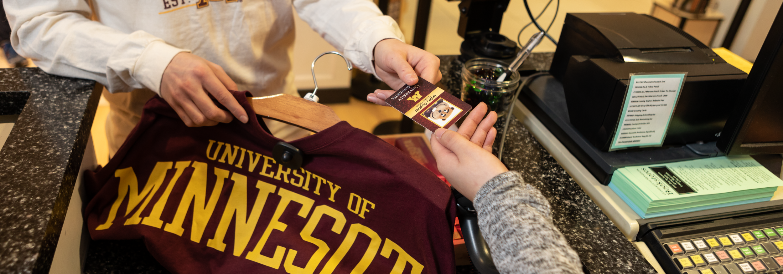 Student purchasing a sweatshirt with their U Card at the U of M Bookstore